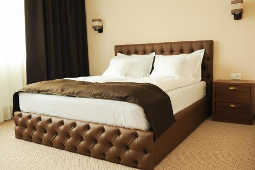 奥拉迪亚Vine Rooms的一间卧室配有一张带皮革床头板的大床