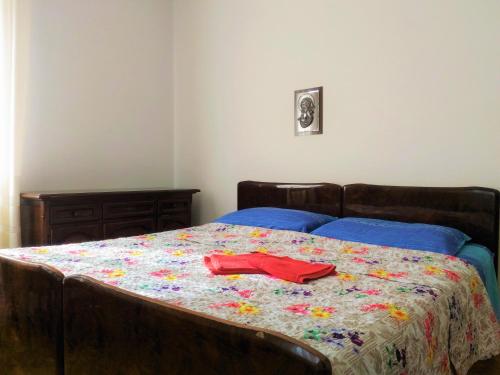 TassulloMELAX Apartment的一张带鲜花棉被的床,上面有红衬衫