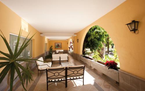 马斯帕洛马斯棕榈绿洲玛斯帕洛玛酒店的走廊设有桌椅和大窗户
