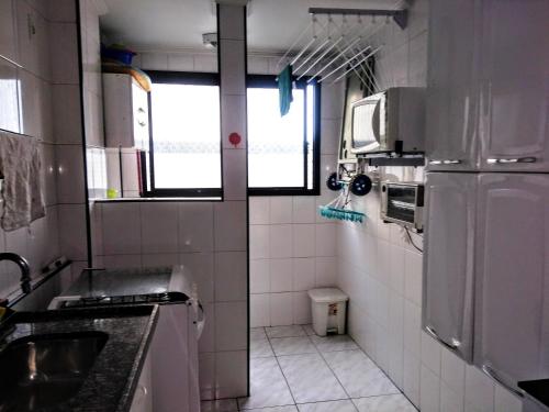 圣维森特岛Apartamento na praia do Itarare的一间带水槽和冰箱的小厨房