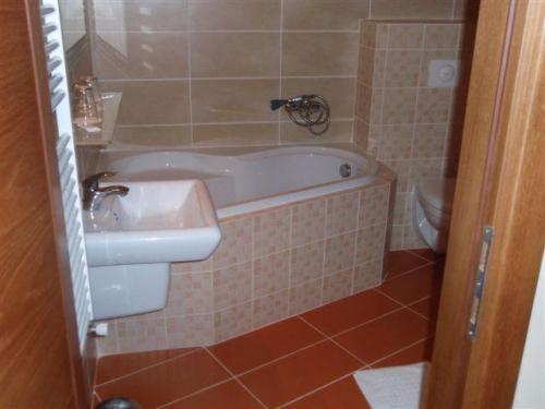 日利纳伽利略酒店 的带浴缸、盥洗盆和卫生间的浴室