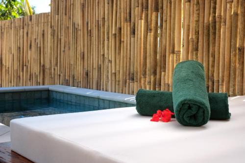 马洛洛莱莱罗马尼岛度假酒店 - 仅限成人入住的床上的绿毛巾