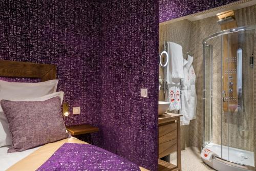 巴黎Le Temple De Jeanne的紫色的客房设有一张床和一间浴室。