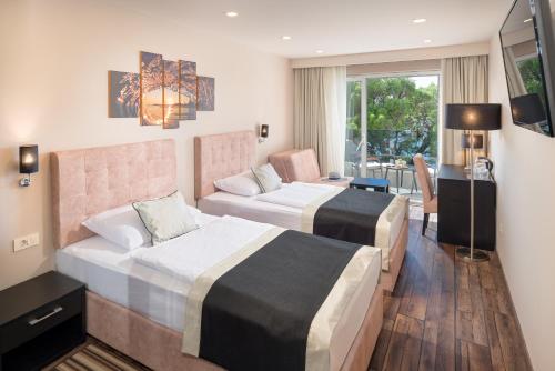 马卡尔斯卡Hotel Central Beach 9的酒店客房配有两张床和一张书桌