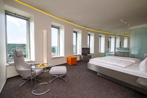 耶拿斯卡拉图姆酒店及餐厅的一间卧室配有一张床、一把椅子和窗户。