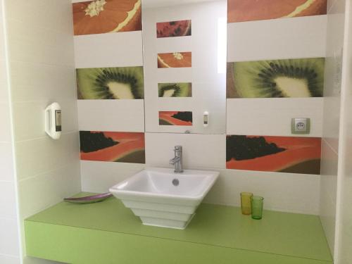 Chénas莱斯德桑纳豪华旅馆的一间带水槽的浴室和墙上的一些图片