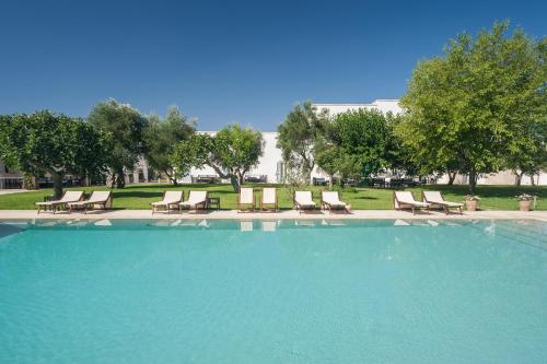 奥特朗托马赛利亚蒙特劳洛酒店的一个带躺椅和树木的大型游泳池