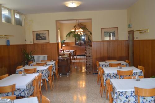 Vaglia帕德里诺酒店的用餐室配有白色的桌子和木椅