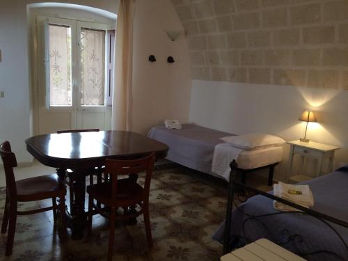 马萨夫拉B&B Corte Laterza的小房间设有桌子、床和窗户
