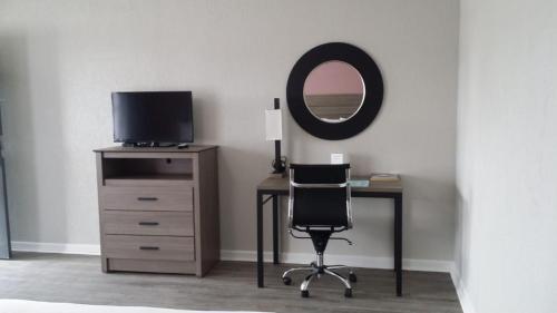 阿比林Econo Lodge Inn & Suites的一张桌子、椅子、电视和镜子