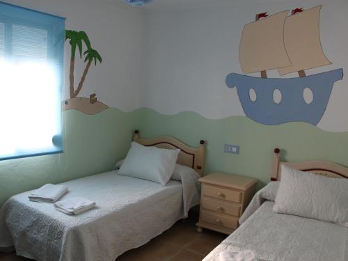 埃尔博斯克ÁTICO CAHI的卧室配有两张床,墙上有一条船