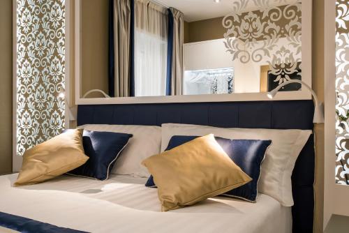罗马Residenza Venti Settembre的卧室配有白色床和蓝色及金色枕头