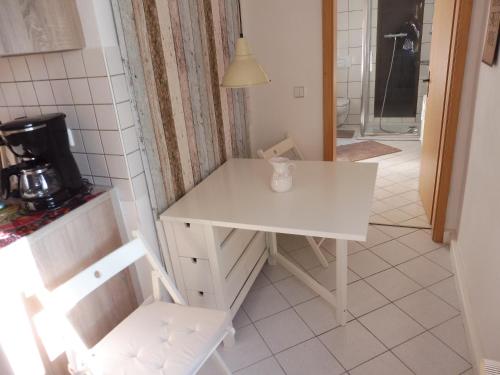 拉德博伊尔Ferienwohnung Simone的厨房里的小白色桌子和椅子