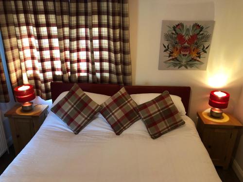 因弗内斯The Wee Lodge的一间卧室配有一张带两个枕头和两个灯的床。