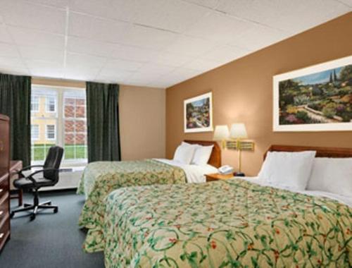 麦迪逊维尔麦迪逊维尔戴斯酒店的酒店客房配有两张床和一张书桌