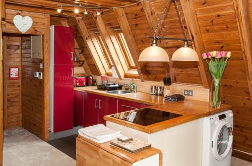 Grafham格拉弗姆水上山林小屋的厨房配有红色橱柜和红色冰箱
