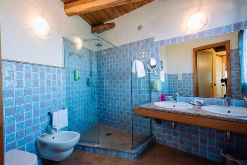卡拉赛达露其德尔法罗酒店的蓝色瓷砖浴室设有2个盥洗盆和1个卫生间
