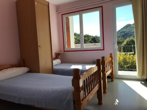 圣吉隆Les chambres et studios Camping Parc de Paletès的一间卧室设有两张床和一个美景窗户。