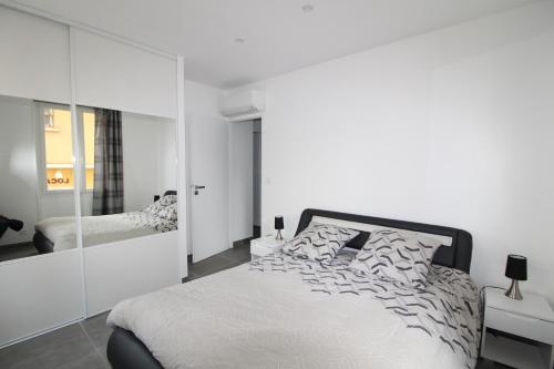 滨海萨纳里Appartement T2 sur le port de sanary的白色卧室配有床和镜子
