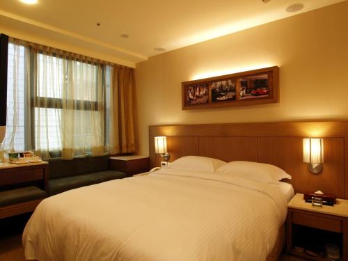 台北東鑫商務旅館Eastern Star Hotel的酒店客房设有一张大床和一张沙发。