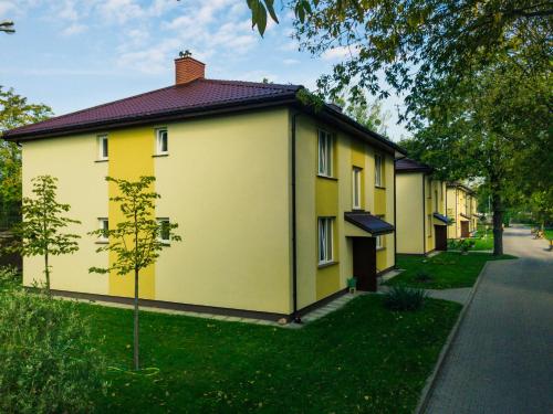 华沙L26 Łopuszańska的街上一排黄色的房子