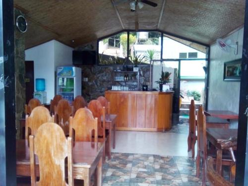 爱妮岛爱妮岛观景台小屋 的餐厅设有木桌、椅子和柜台