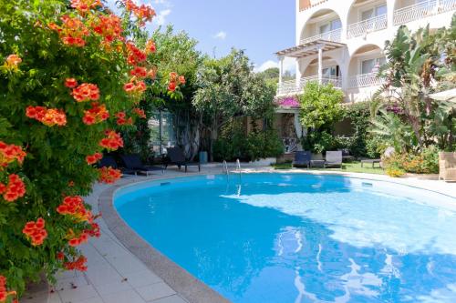 维拉西米乌斯西缪斯培拉亚酒店的鲜花盛开的建筑前的游泳池