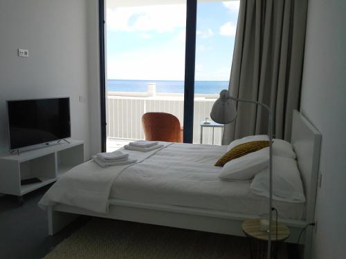 蓬塔穆赫雷斯Sargo的一间卧室配有一张床,享有海景