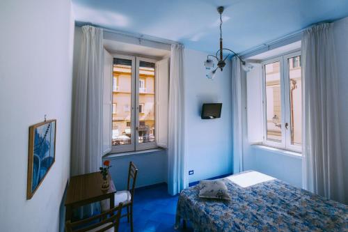 阿马尔菲圣安德烈旅馆的蓝色的客房设有一张床和两个窗户。