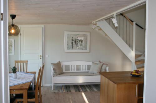 BlidsbergDrängstugan i Humla的客厅配有白色长凳和桌子
