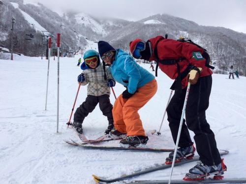 白马村Piremon的雪上滑雪的2名成人和1名儿童