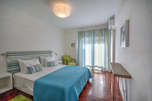 法鲁In Faro with Sea View的一间卧室配有一张带蓝色毯子的床