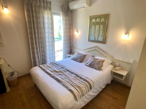 勒拉旺杜Hôtel Méditerranée的卧室配有一张大白色床和窗户