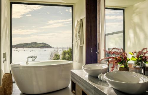 归仁Anantara Quy Nhon Villas的一间带两个盥洗盆的浴室和一个大窗户