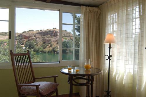 鲁伊德拉La Buena Siesta的客房设有桌子、椅子和窗户。