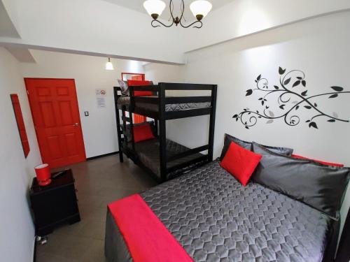 危地马拉Cayalito Apart Hotel的一间卧室设有双层床和红色的门。