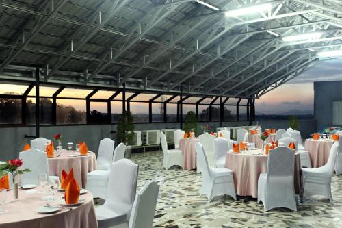 丹戎潘丹哈迪卡大酒店的宴会厅配有白色的桌子和白色的椅子