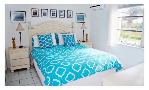 自由港市Beauport One-Bedroom Apartment的一间卧室配有一张带蓝色和白色棉被的床