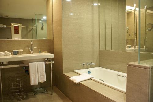芦竹尊爵天际大酒店的带浴缸和盥洗盆的浴室