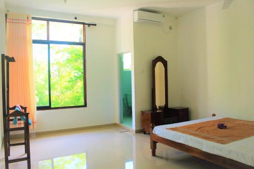 马特勒Samanala Resort的一间卧室设有一张床和一个大窗户