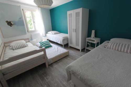 科尔马Subtil insolite的一间卧室设有两张床和蓝色的墙壁