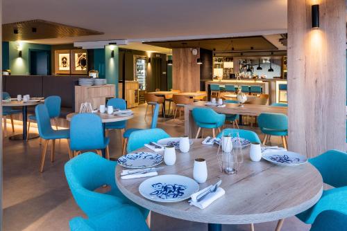 阿利坎特Hotel Alicante Gran Sol, affiliated by Meliá的一间配备有桌子和蓝色椅子的用餐室
