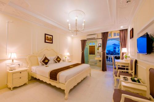 会安会安花园宫Spa酒店的一间卧室配有一张大床和一个吊灯。