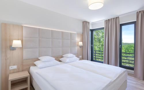 斯克拉斯卡波伦巴Blue Mountain Resort的卧室设有白色的床和大窗户