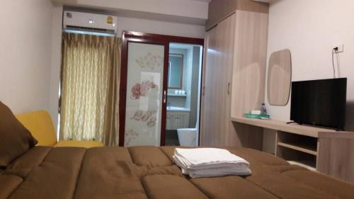 曼谷Roseate Bangkok Hotel的一间卧室配有一张带电视和镜子的床