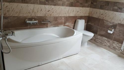 鲁塞Jorela Family Hotel的浴室配有白色浴缸和卫生间。