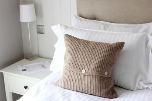 伦敦华克斯昂酒店的一张带棕色枕头和白色床头柜的床