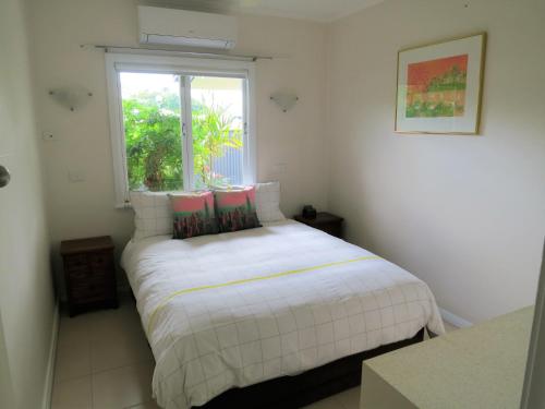 凯恩斯Edge Hill Clean & Green Cairns, 7 Minutes from the Airport, 7 Minutes to Cairns CBD & Reef Fleet Terminal的窗户客房内的一张白色床