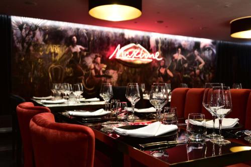 里斯本Maxime Hotel Lisbon的餐厅设有长桌和酒杯
