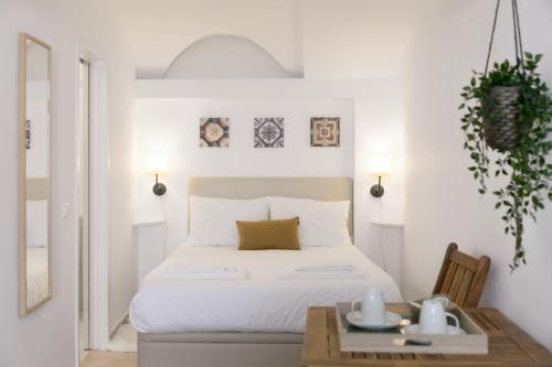埃武拉Casa Candeias的白色卧室配有床和桌子